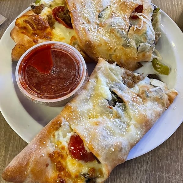 Mike's Pizza and Pub's calzones and strombolis with a side of marinara sauce.